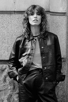 Woman posing in leather jacket.